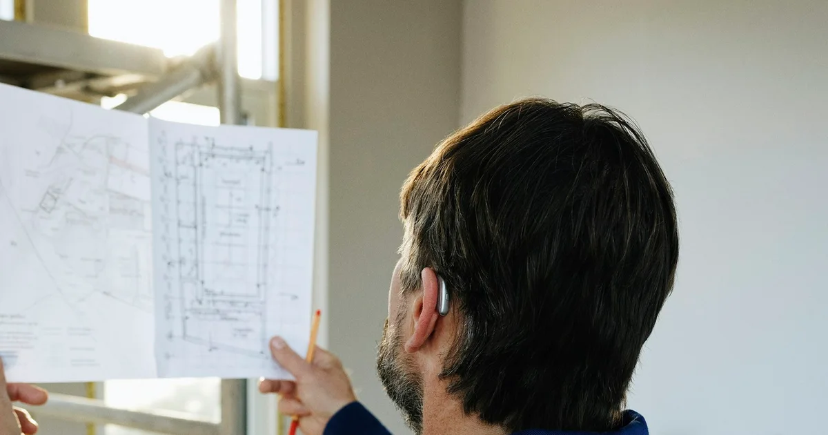 Construction manager reviewing a set of blueprints on an active job site