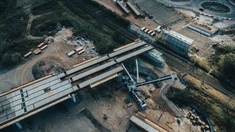 Aerial view of a bridge construction project with heavy civil equipment and structural work in progress