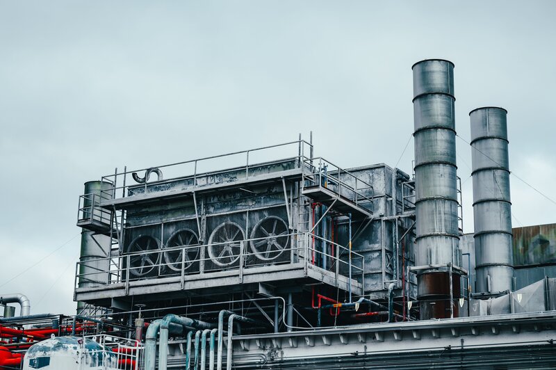 Industrial factory building exterior with pipe systems and process equipment